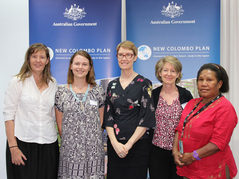 Official standing in front of New Colombo Plan logos.