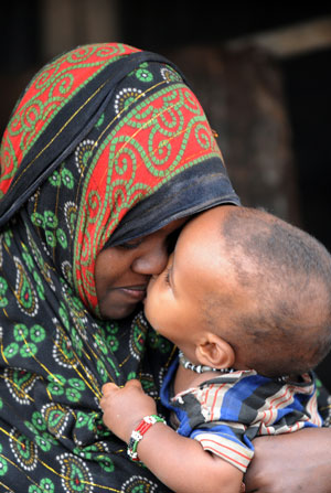 Photo of a young mother touching foreheads with her child.