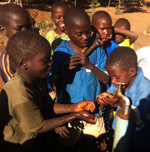 Photo of children drinking from a safe water tap.