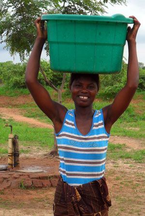 Photo of a boy holding a tub of drinking water.