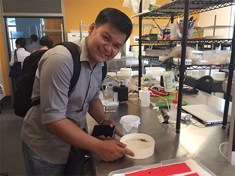 Man in a science lab smiling at camera