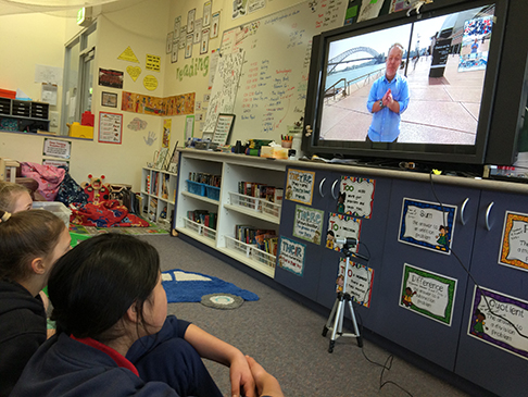 Group of young students watching television in  a classroom