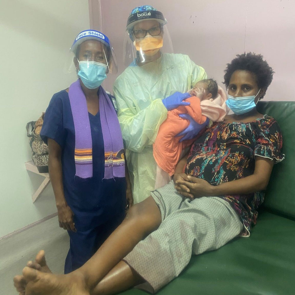 Photo of AUSMAT nurse Theona Stone and Port Moresby General Hospital nurse Elice with a mother and her new born baby. 