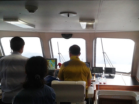 Two men in ship looking out to sea