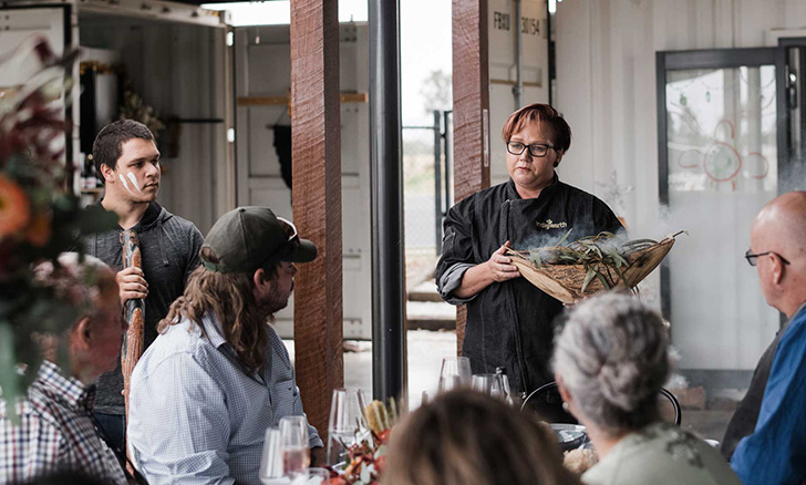 Chef speaking in front of guests.