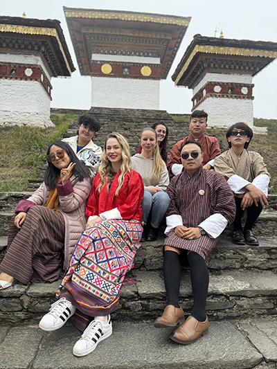 Samantha sitting on the stairs of Dochula Pass with friends.