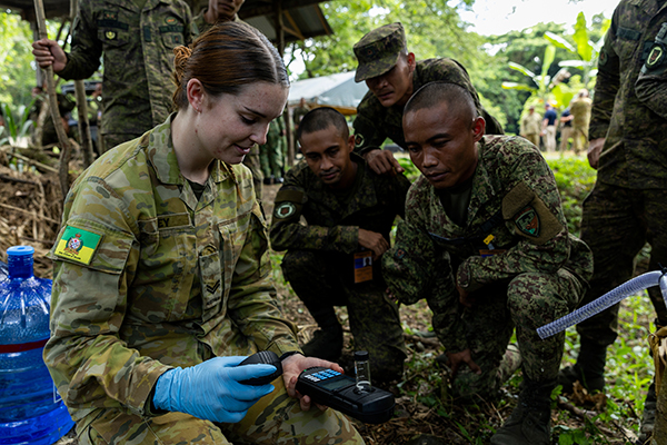 A group of soldiers watching a demonstration of new technology. 