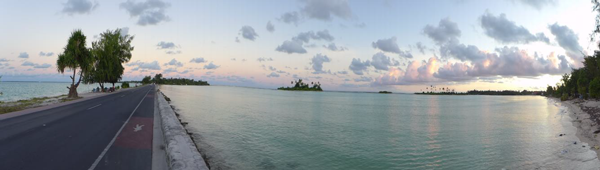 a narrow road stretches between two bodies of water, leading to a small island