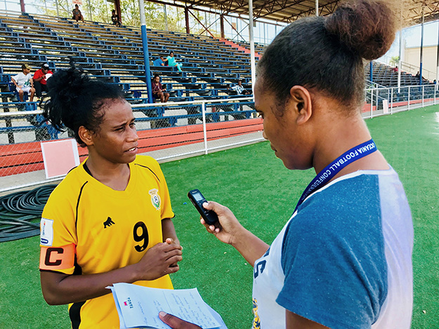 Journalist holding audio recording device conducting interview with sports person.