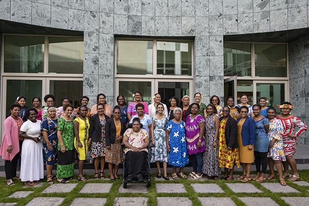 Group of women from the Pacific posing for photograph in courtyard.