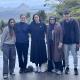 Five New Colombo Plan scholars smiling with trees and a mountain in the background