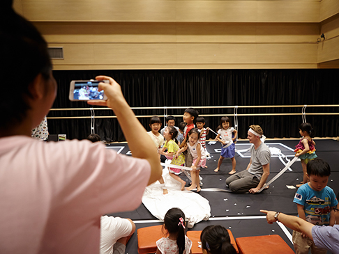 An adult taking a photo of children on the This and That stage